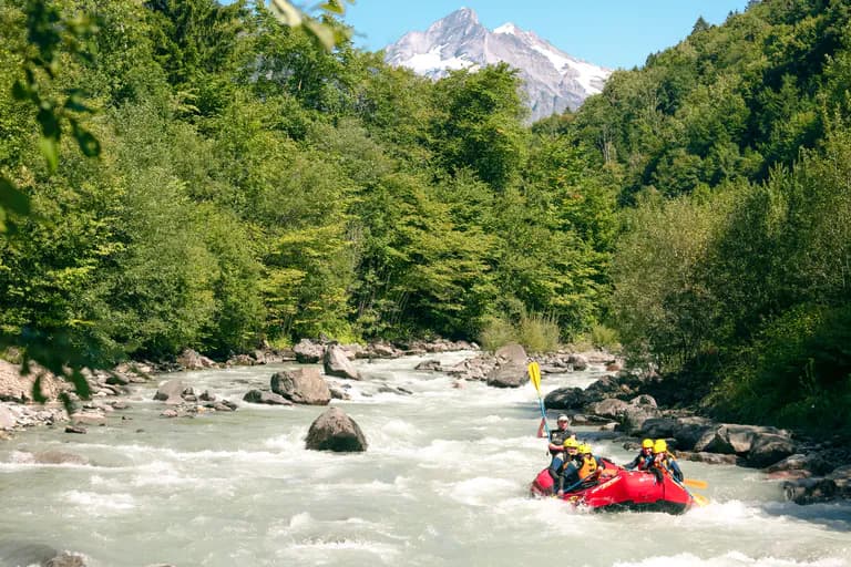 River Rafting mit Boot auf dem Fluss und Bergen im Hintergrund